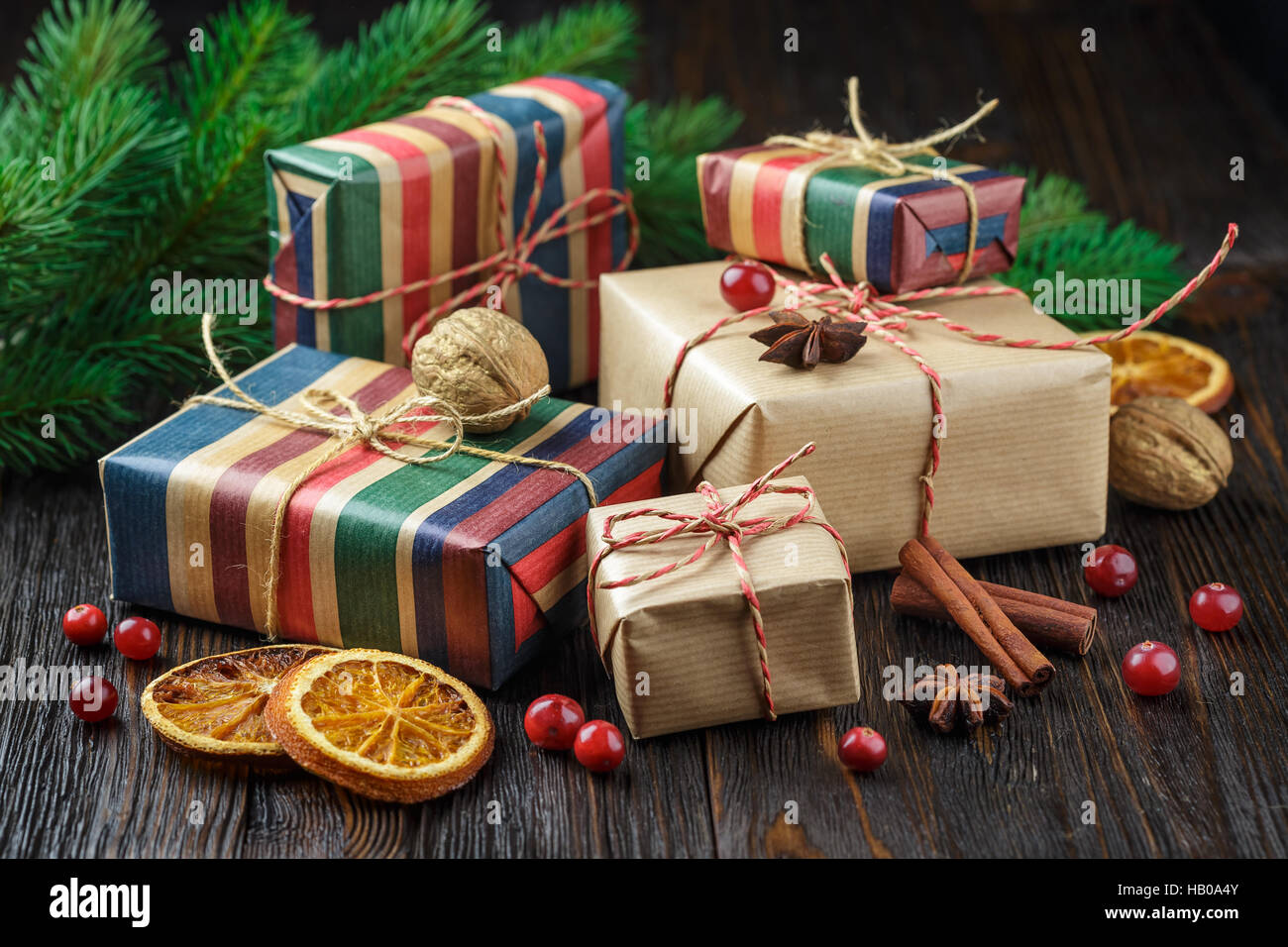 Weihnachtsgeschenke, Zimt, Anis Sterne, Preiselbeeren Beeren und Fichte Zweige auf einem hölzernen Hintergrund Stockfoto