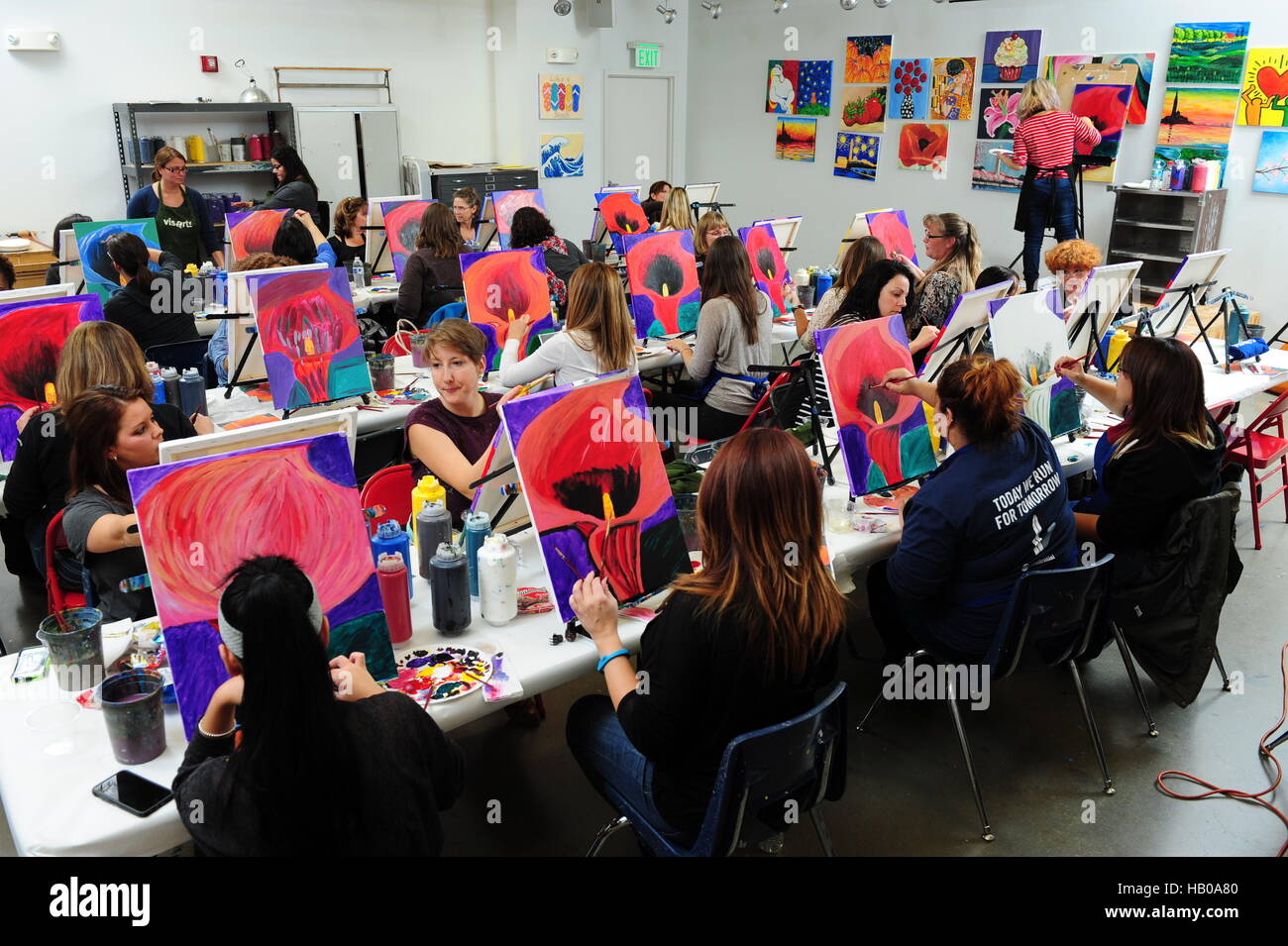 Erwachsenenbildung Kunst Klasse Menschen, die Blumen in einem Abend Klassenzimmer zu malen lernen Stockfoto