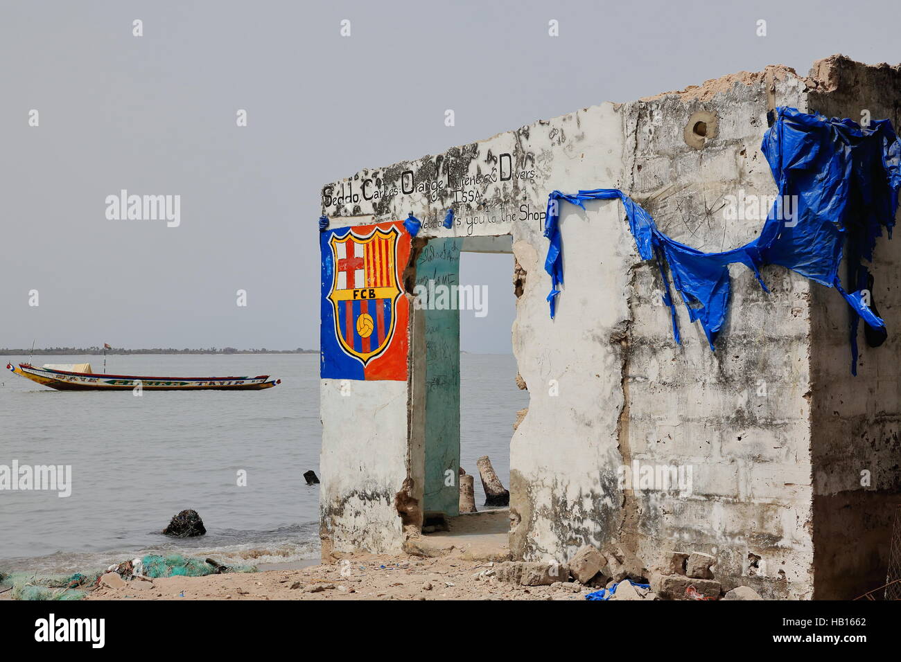 Diogue Insel, Senegal-April 15, 2014: die Ruinen eines verlassenen Ladens am Ufer mit Blick auf die Mündung des Flusses Casamance noch zeigen Spuren der Grossgärtnerei Stockfoto