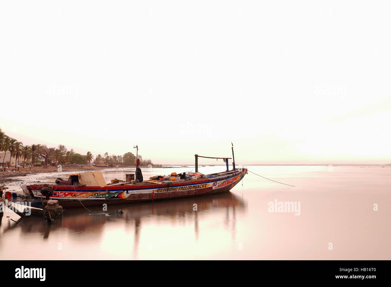 Ziguinchor, Senegal-April 16, 2014: Hölzerne Schiffe, Angeln und Segeln nach oben und unten des Casamance Fluß Ankers auf der Anklagebank, denn über Nacht vor Anker Stockfoto