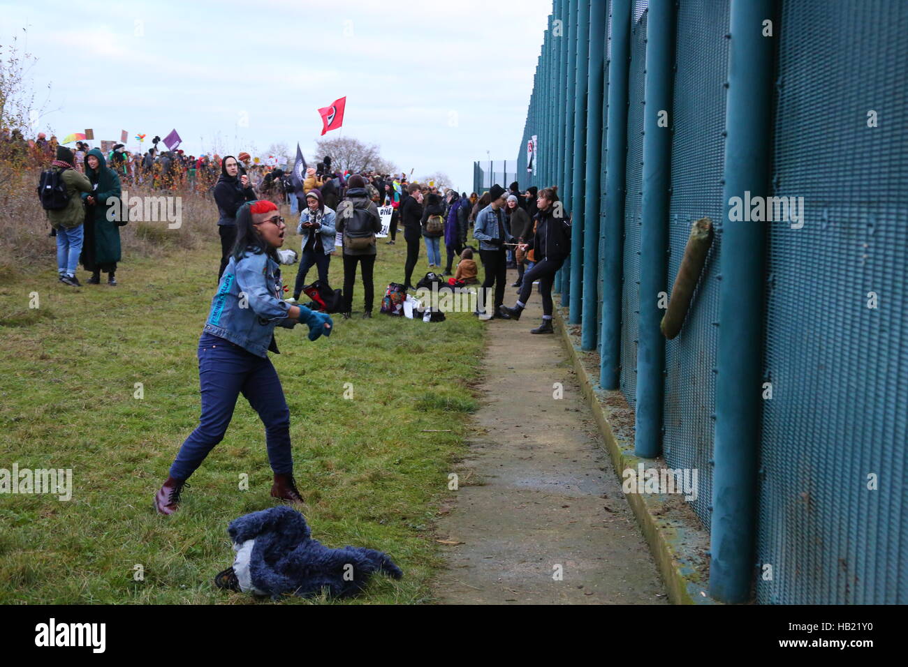 Yarls Holz Haftanstalt, Bedford. 3. Dezember 2016. Eine Frau Demonstrant wirft einen Zaunpfahl am Zaun. Fast 2000 Demonstranten protestieren am Zaun des Zentrums für Yarls Holz in Guantánamo geschlossen werden musste. Bildnachweis: Penelope Barritt/Alamy Live-Nachrichten Stockfoto