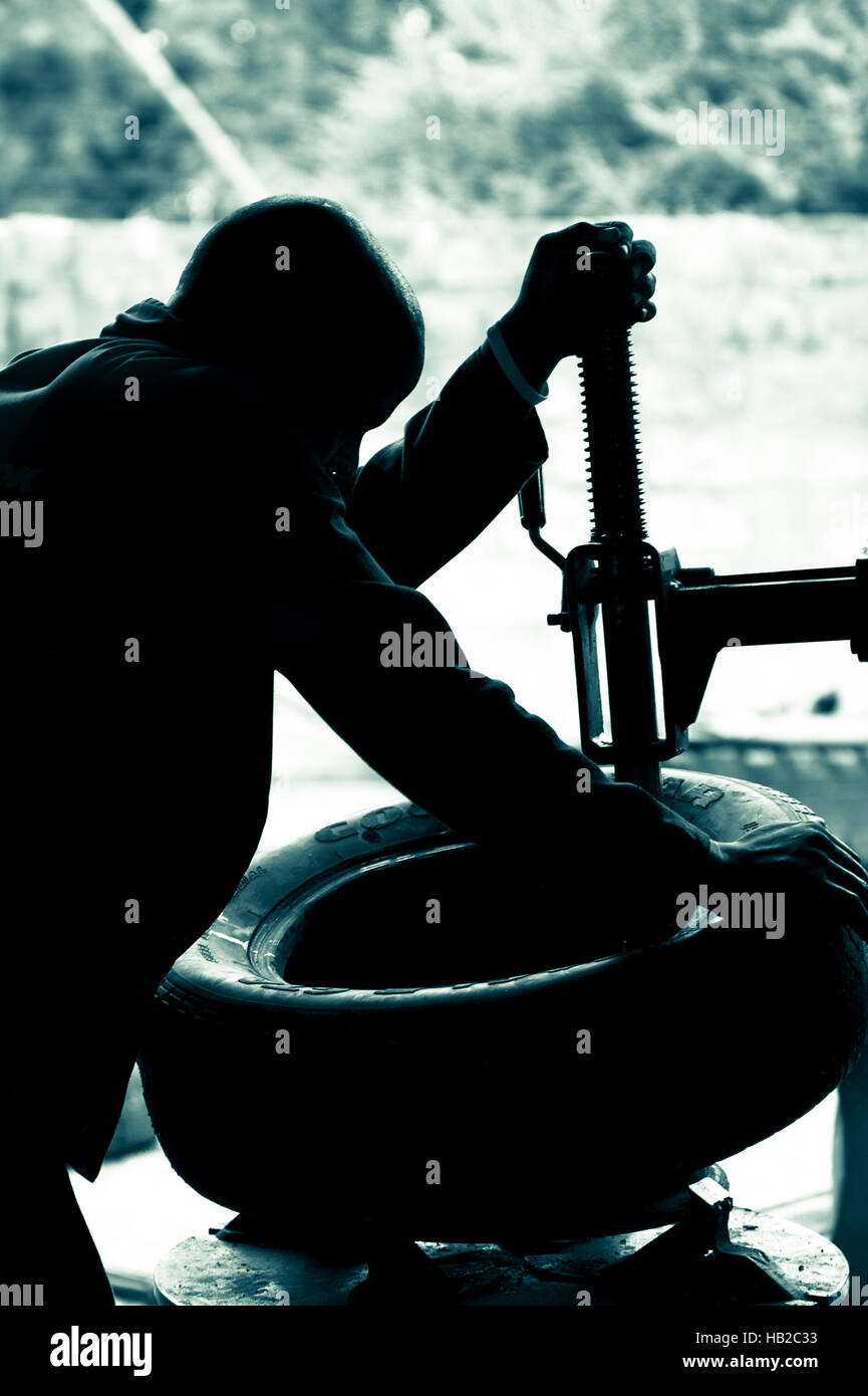 Mechaniker bei Arbeiten Befestigung Reifen in einer Garage Namibia. Stockfoto