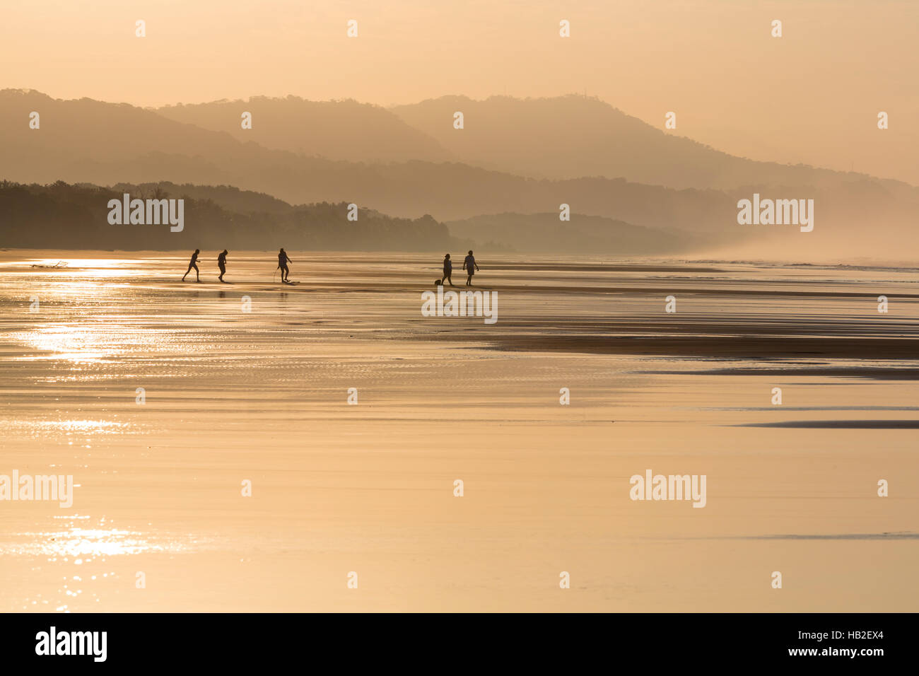 Silhouetten von zwei Menschen, die zu Fuß am Strand Stockfoto