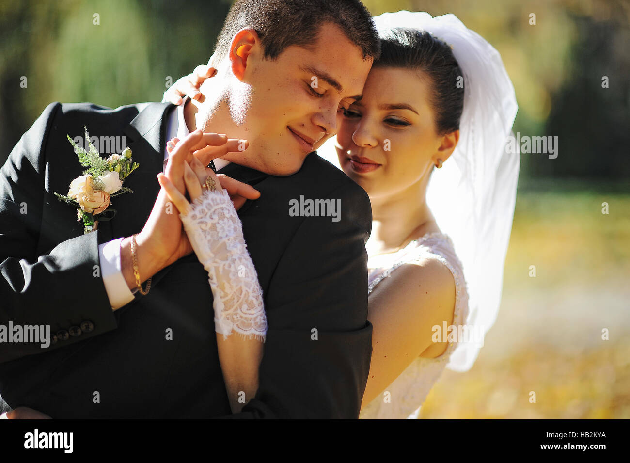 Glühende Hochzeitspaar umarmen schließen sich Stockfoto
