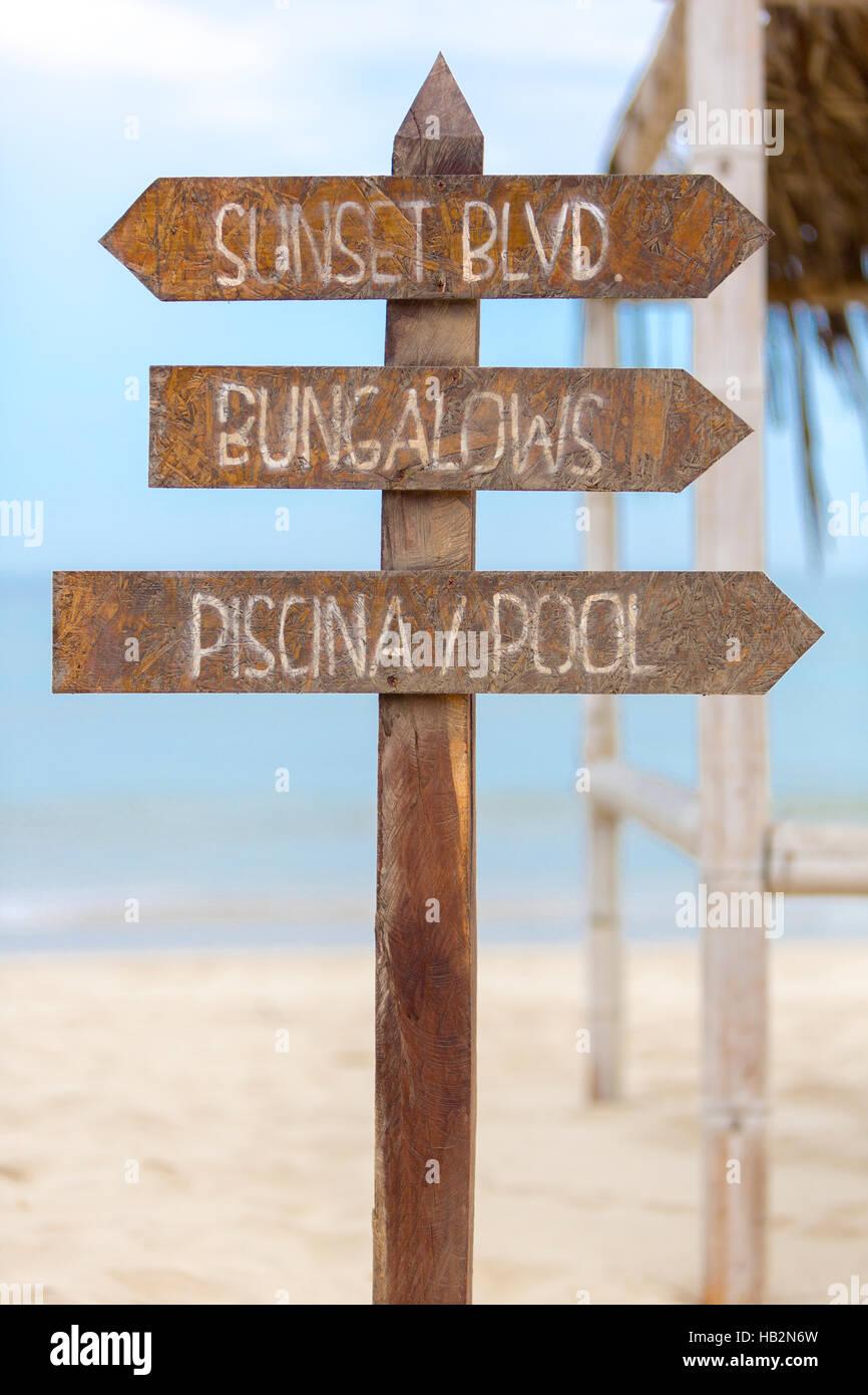 Holzschild Posten stehen am Strand und die Richtung für die Bungalows und das Schwimmbad am Strand von Punta Sal, Peru Stockfoto