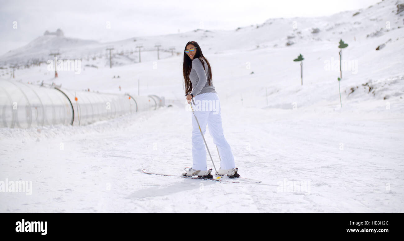 Nette Frau auf Skiern am Fuß des Berges Stockfoto