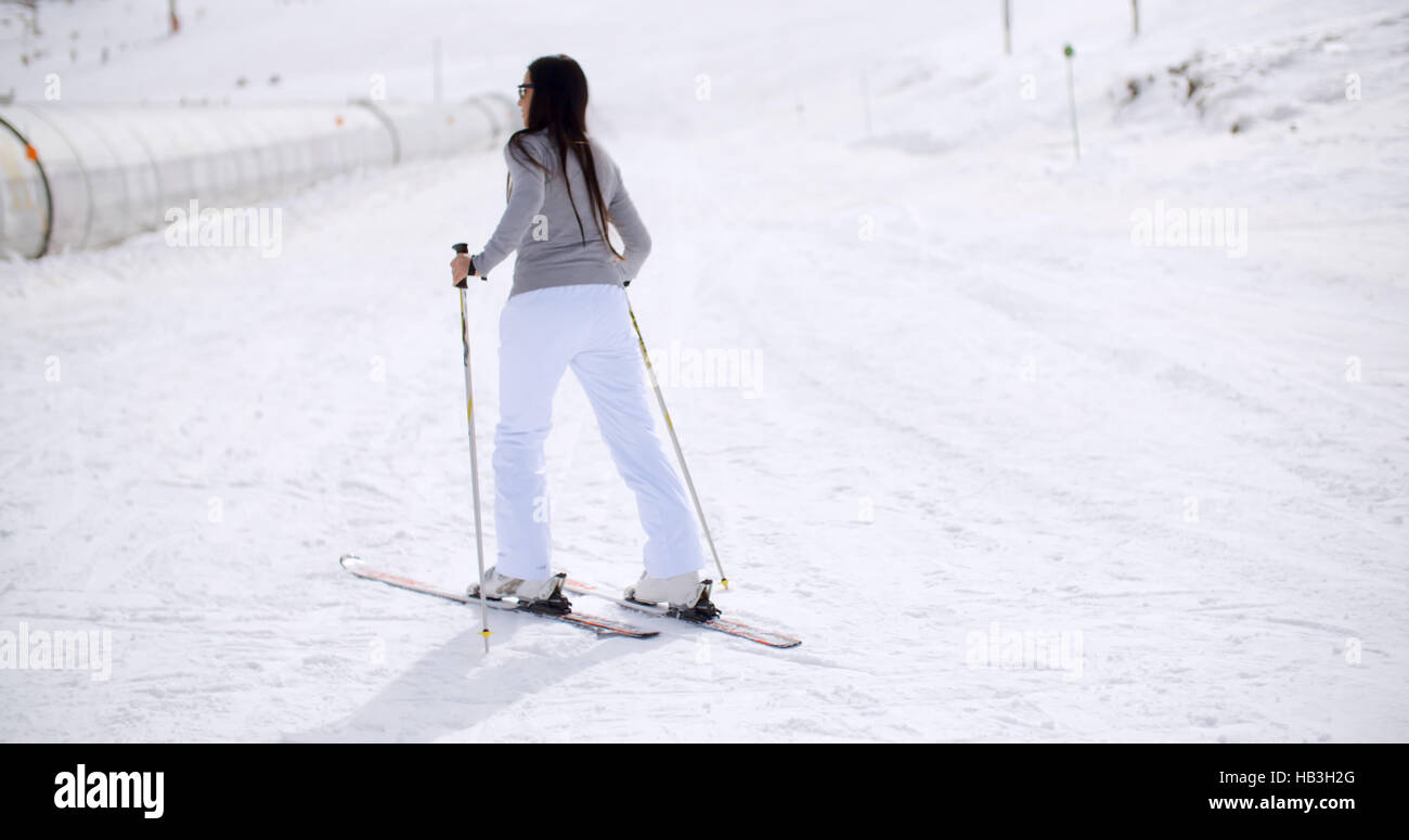Nette Frau auf Skiern am Fuß des Berges Stockfoto