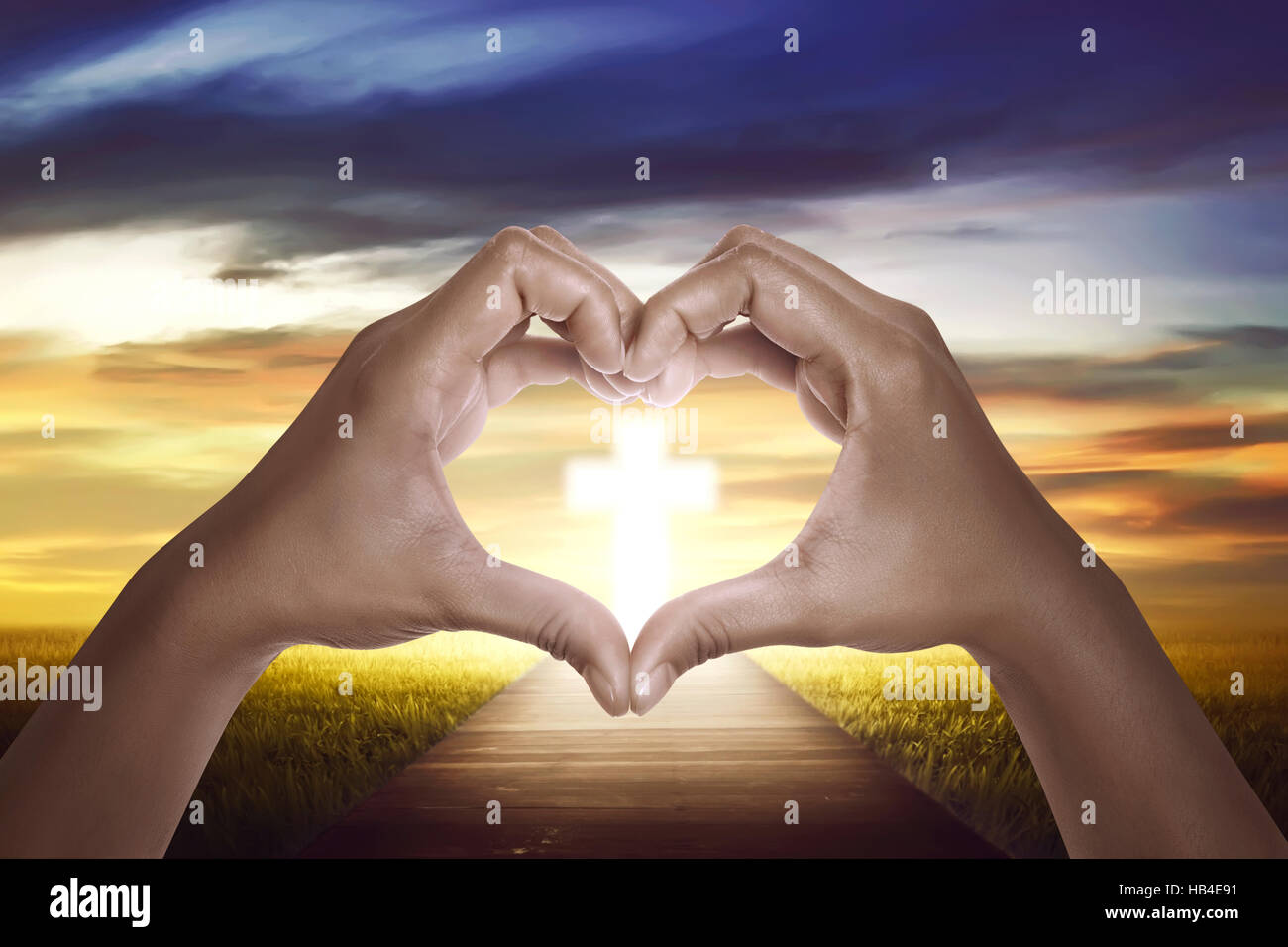 Handzeichen Form Liebe mit christlichen Kreuz am Himmel Stockfoto