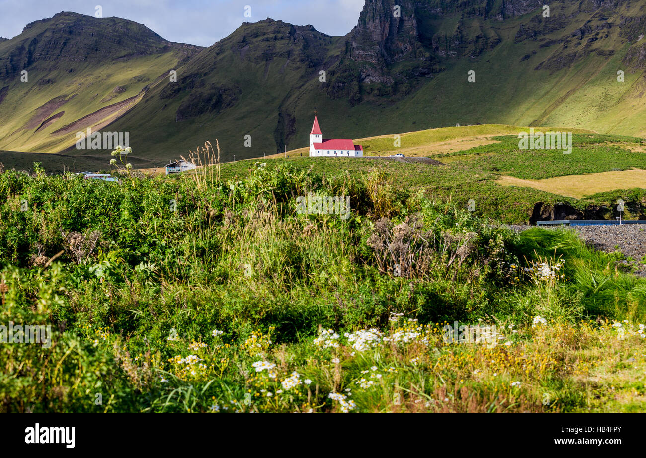 Weiße Kirche mit rotem Dach auf einem Hügel im Süden Islands. Stockfoto