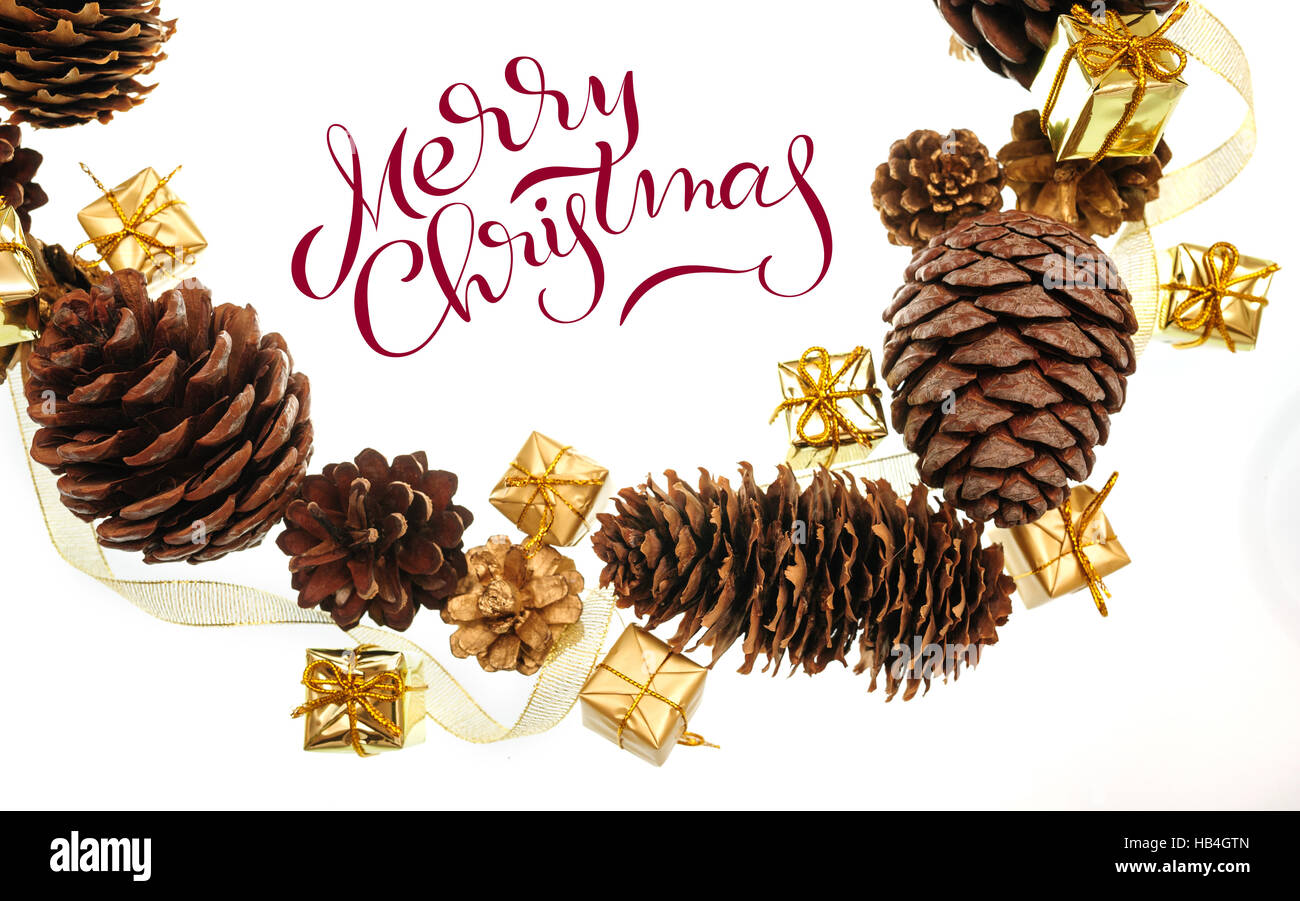 Rahmen der Zapfen und Geschenke auf weißem Hintergrund mit Text Frohe Weihnachten. Kalligraphie-Schriftzug Stockfoto