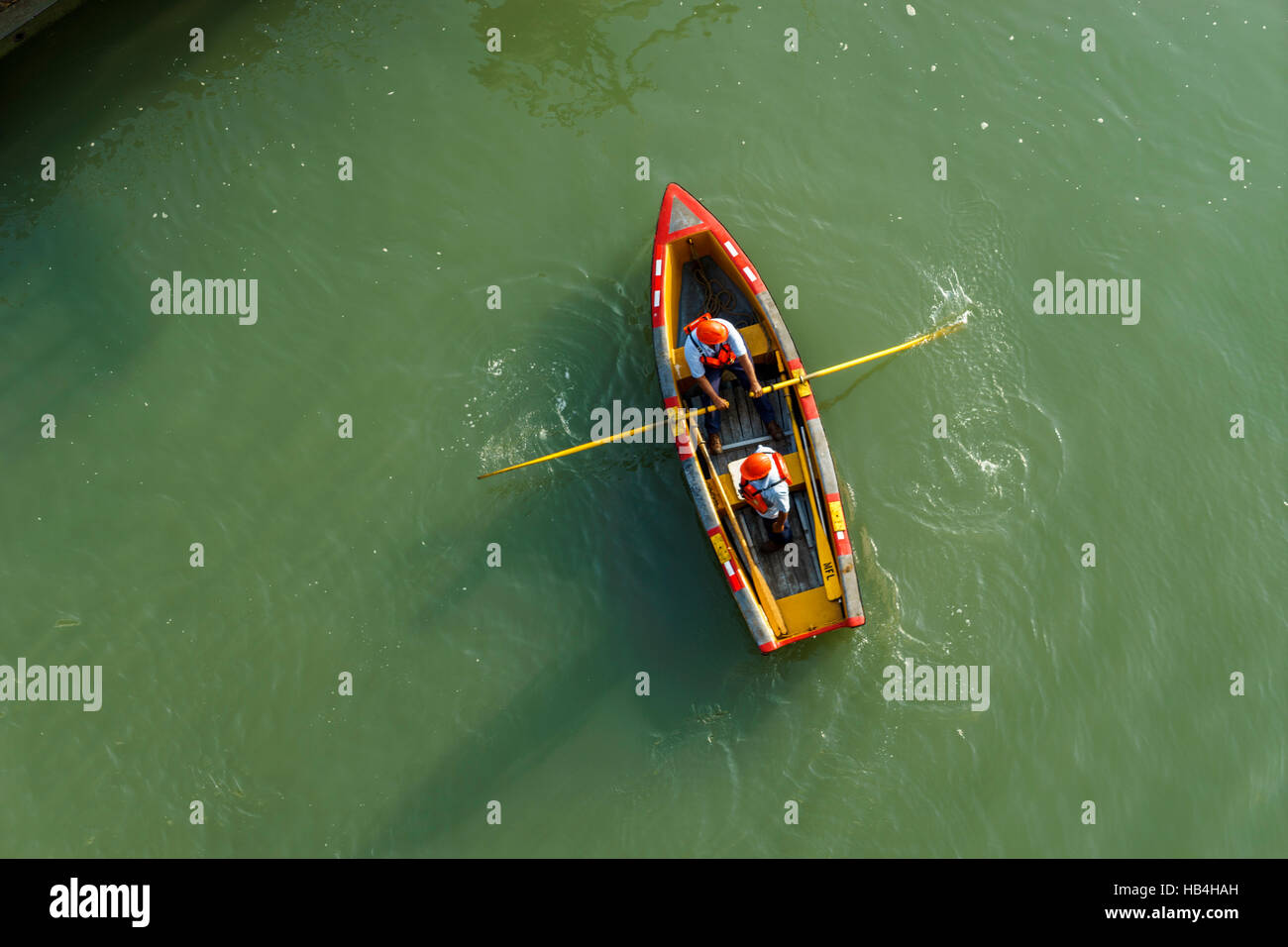 Zwei Männer in einem Ruderboot, die die Schiffe in den Panama-Kanal von oben gesehen die Zeilen übergeben Stockfoto