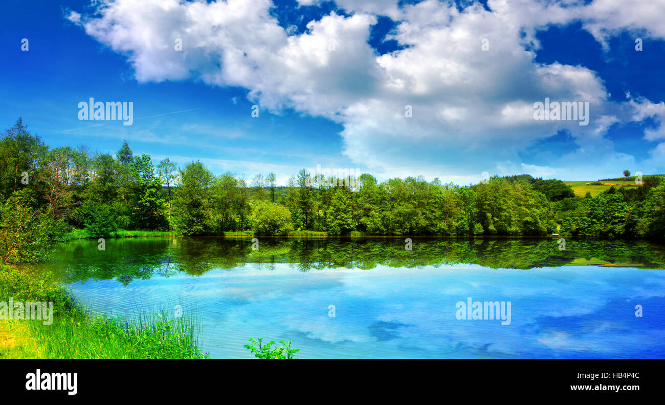 See und grüne Bäume auf Himmelshintergrund. Stockfoto