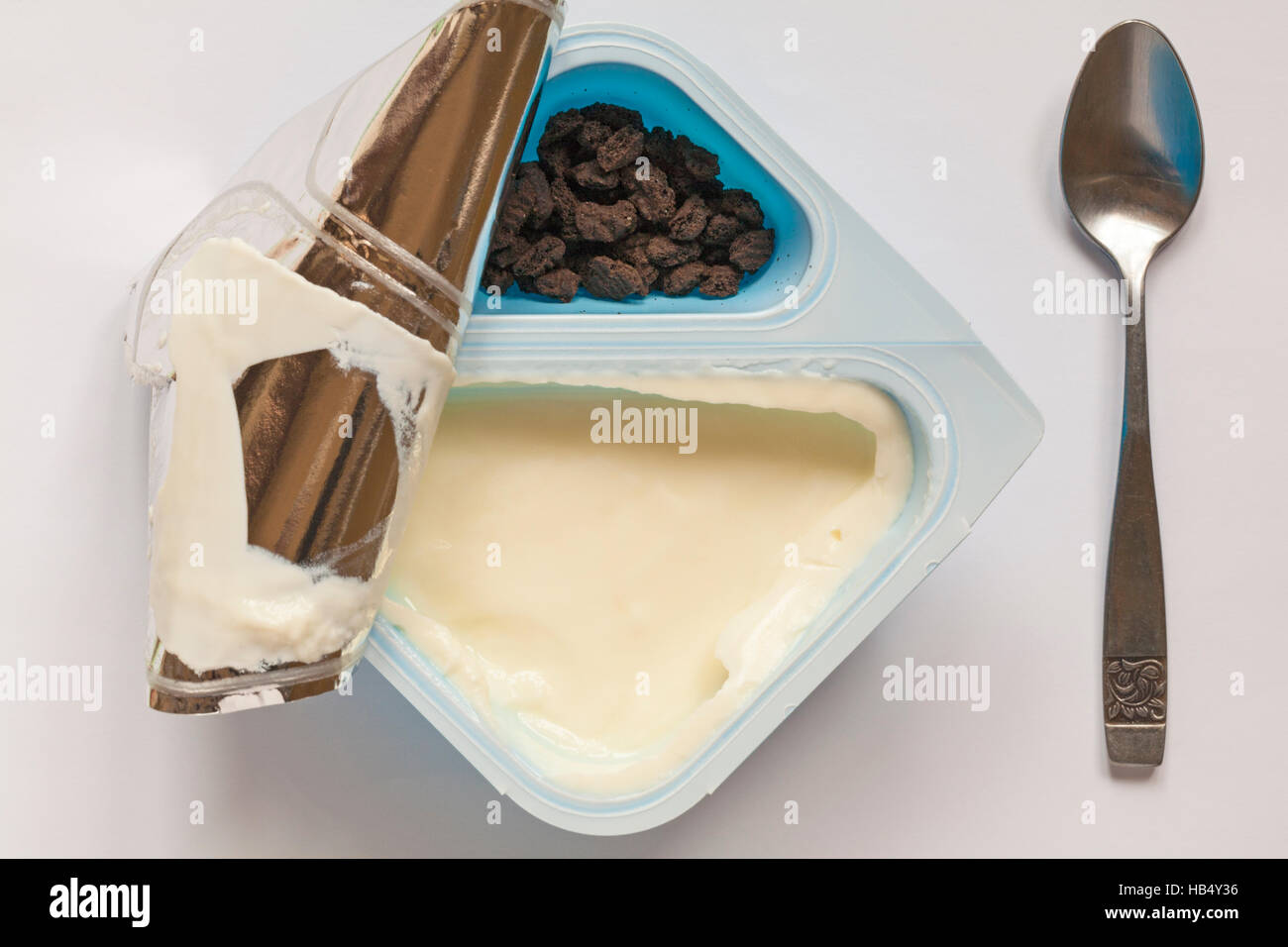 Topf mit neuen Oreo Vanille Joghurt mit Oreo Cookie crumb mit Deckel wieder abgezogen zu Inhalt und Löffel auf weißem Hintergrund - Joghurt zeigen Stockfoto