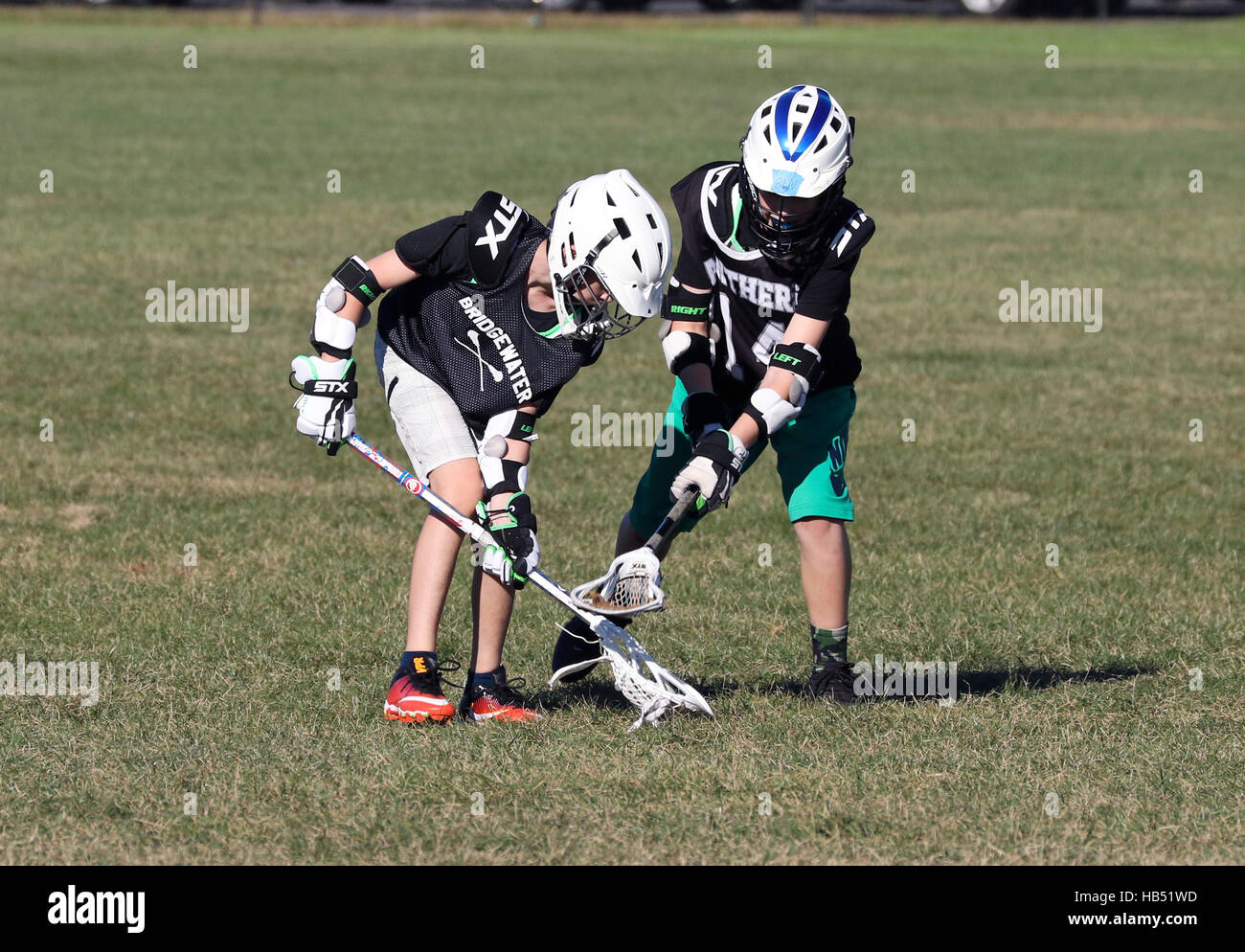 Zwei 10 Jahre alte Jungen lacrosse spielen. Stockfoto