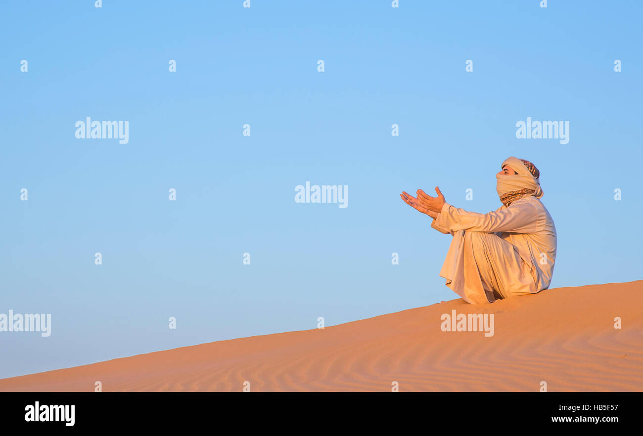 Mann in traditioneller Kleidung in einer Wüste bei Sonnenaufgang in der Nähe von Dubai Stockfoto