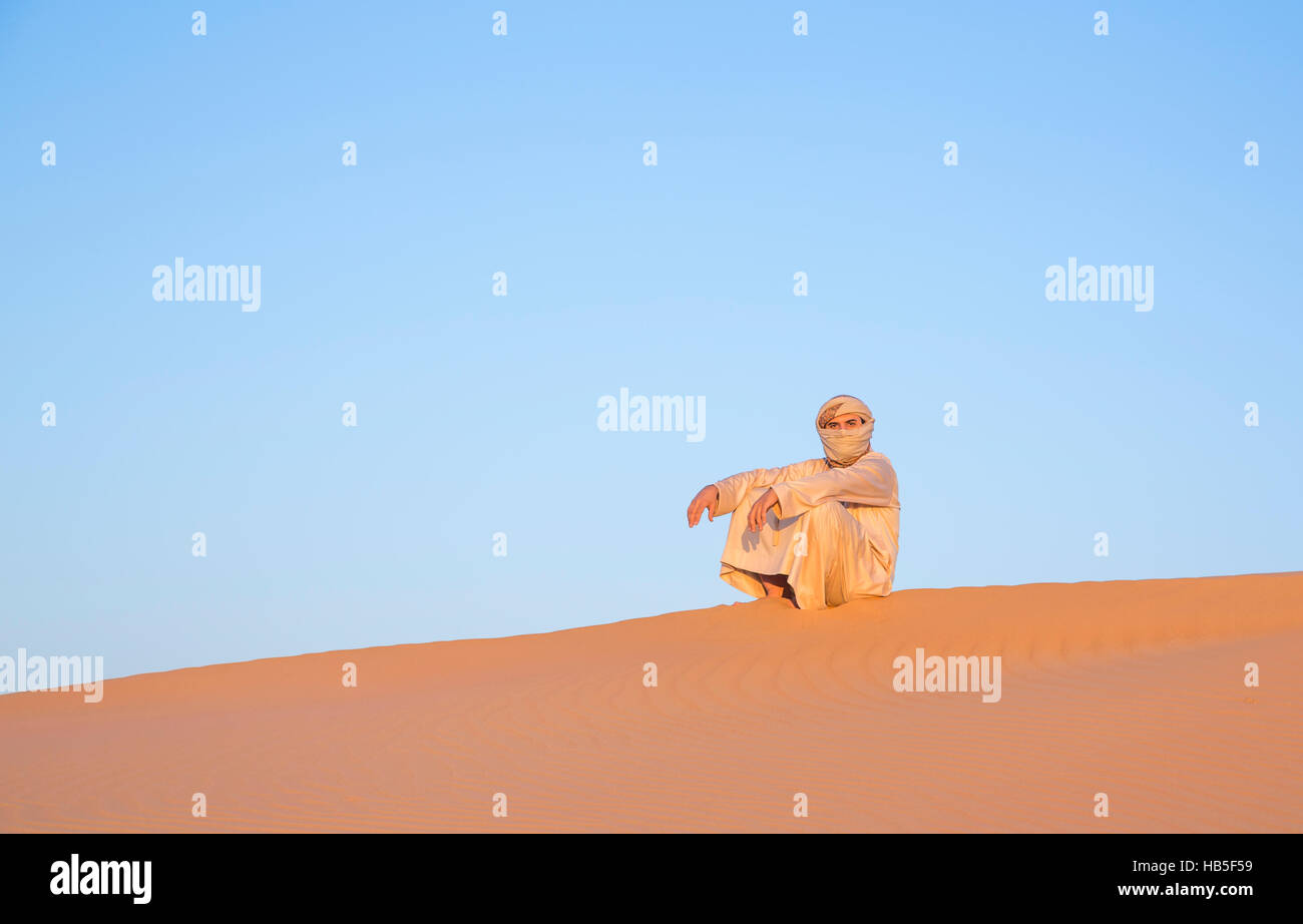 Mann in traditioneller Kleidung in einer Wüste bei Sonnenaufgang in der Nähe von Dubai Stockfoto