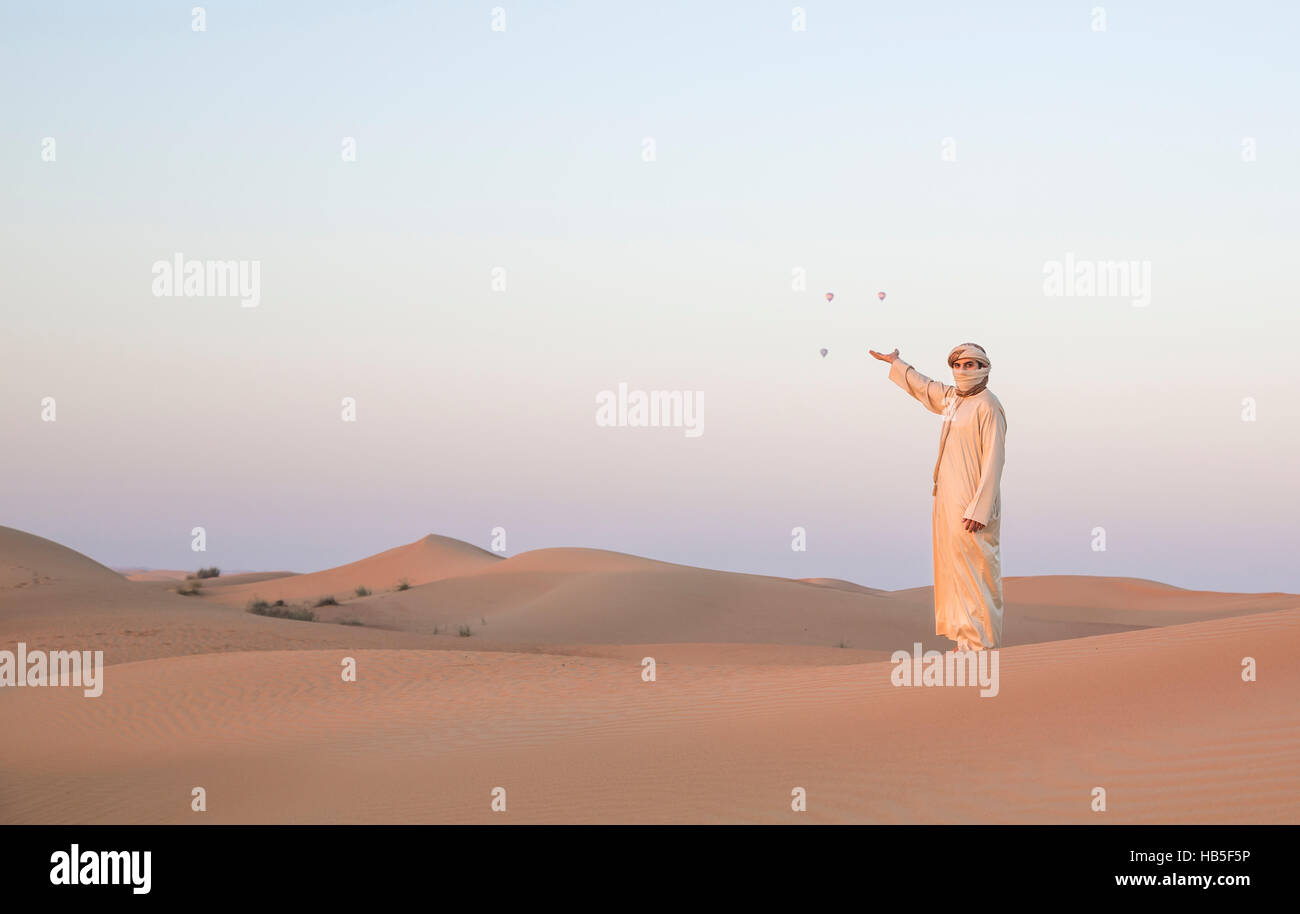 Mann in traditioneller Kleidung in einer Wüste bei Sonnenaufgang in der Nähe von Dubai Stockfoto