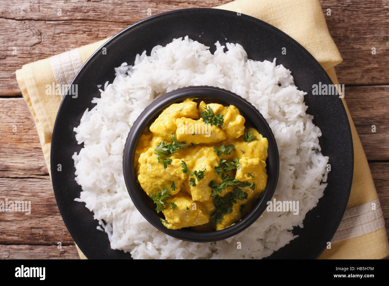 Indische Küche: Korma Hühnchen in Kokosnuss-Sauce und Basmati-Reis-Nahaufnahme auf dem Tisch. horizontale Ansicht von oben Stockfoto