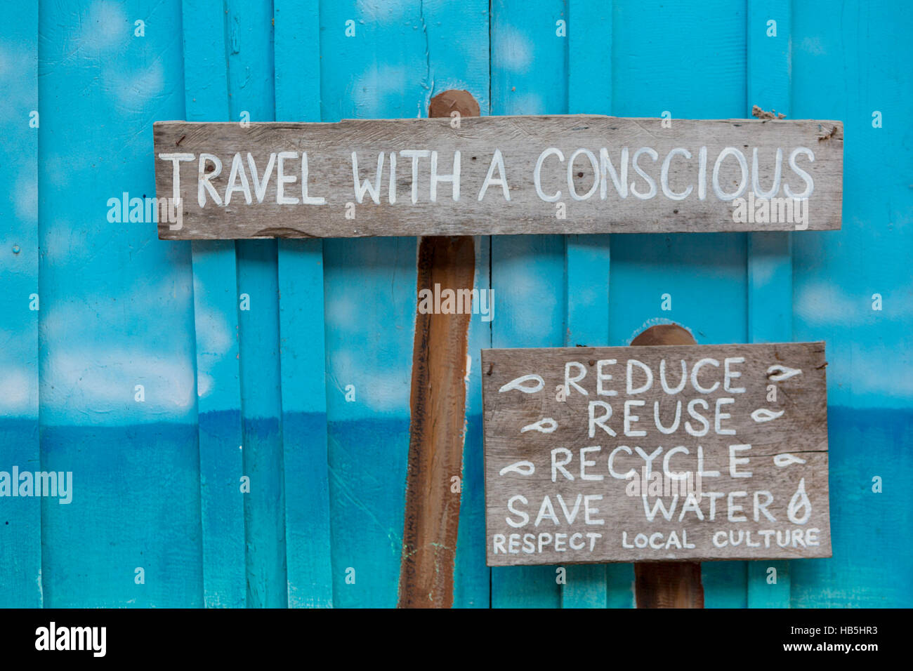 Reisen Sie mit einer bewussten Holzschild auf blauem Hintergrund aus Holz Stockfoto