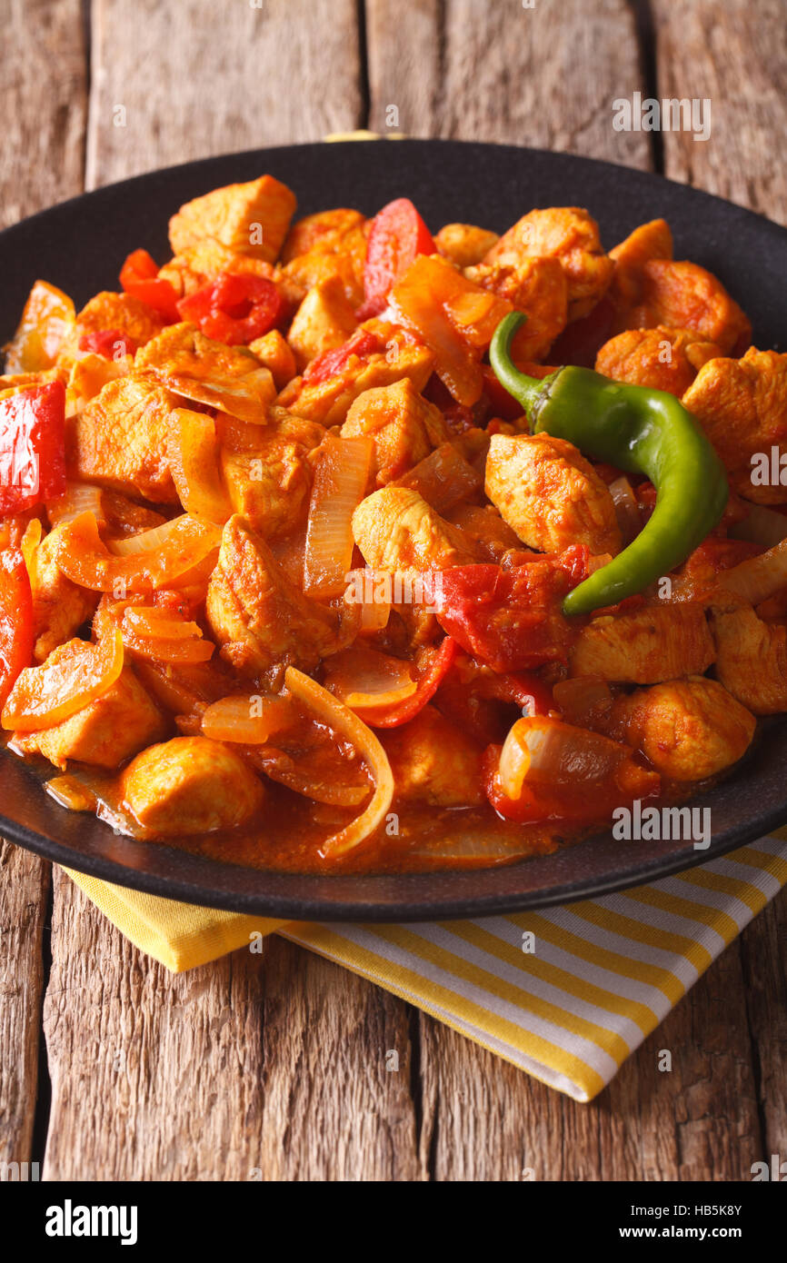 Indisches Essen: würzige Chicken Jalfrezi mit Zwiebeln und Paprika in Tomaten-Sauce Nahaufnahme auf einem Teller auf den Tisch. vertikale Stockfoto