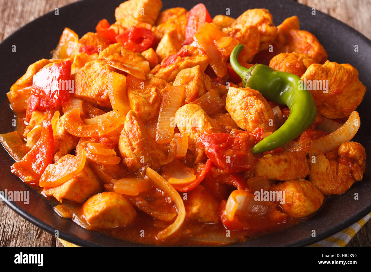 Beliebte indische Curry Chicken Jalfrezi Huhn rühren gebraten mit Gewürzen, mit Tomatensauce und rote und grüne Paprika Makro. horizontale Stockfoto