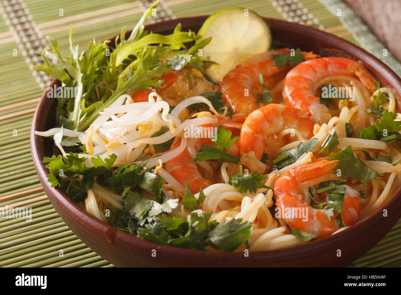 Malaysische Laksa Suppe mit Garnelen hautnah in einer Schüssel auf dem Tisch. horizontale Stockfoto