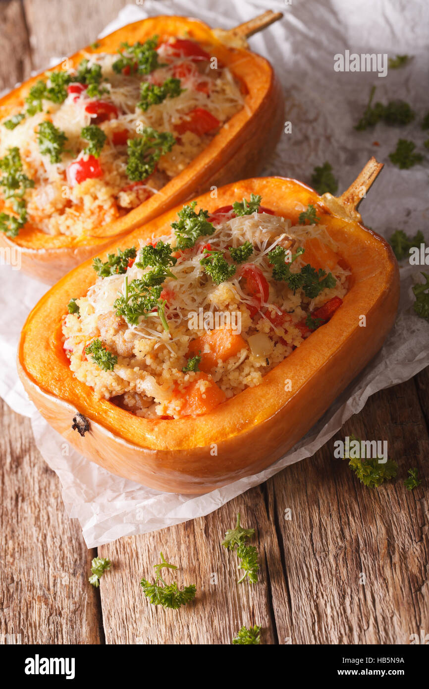 Gebackener Kürbis gefüllt mit Couscous, Fleisch und Käse Nahaufnahme auf dem Tisch. Vertikal Stockfoto