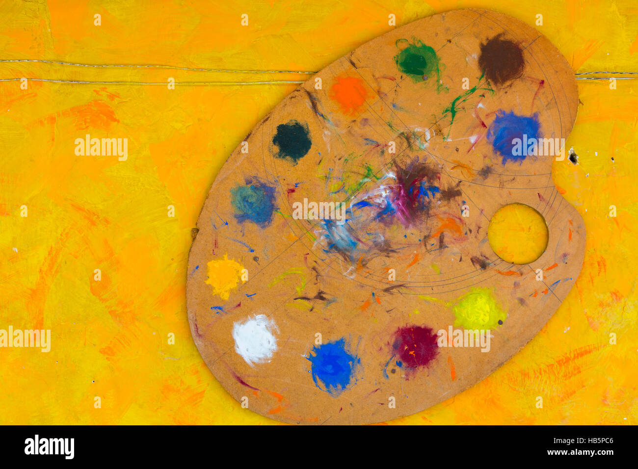 Bürsten und bunten Ölfarben abstrakte Maler Palette auf gelbem Hintergrund Stockfoto