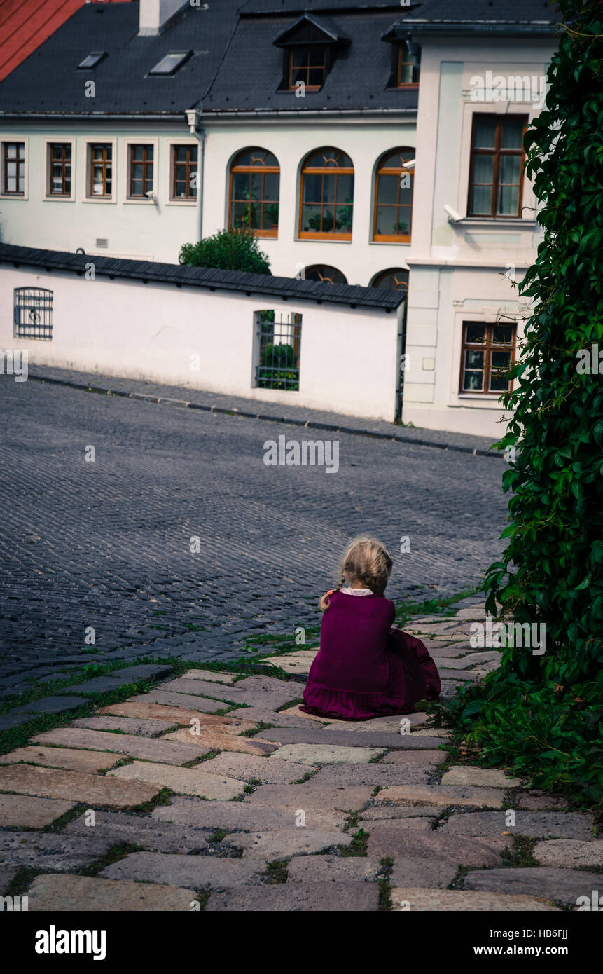 verlorene Mädchen verlassen sitzen im Pflaster Stockfoto