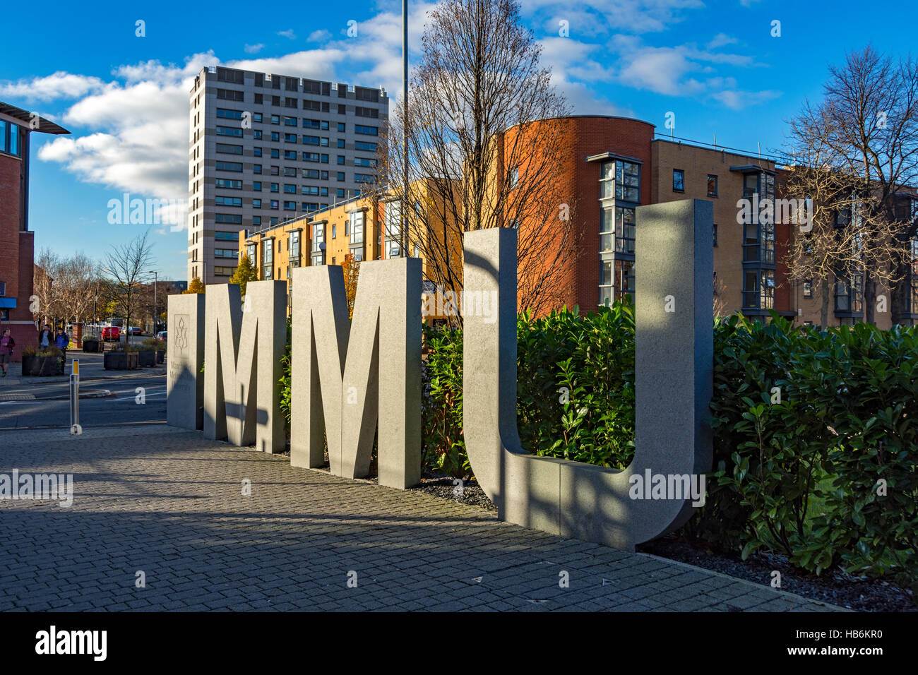Großer Stein oder Beton MMU-Zeichen für Manchester Metropolitan University, auf einem Steg off Grenze Lane, Manchester, UK Stockfoto