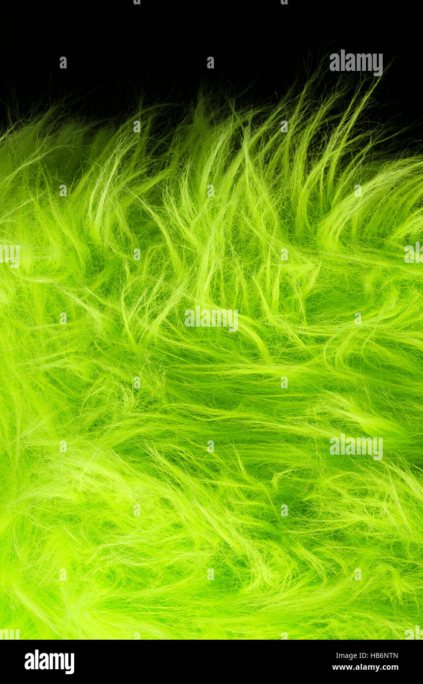 Gelb grüner Stoff auf schwarzem Hintergrund vertikale. Sehr weicher Polyester-Textilien hergestellt aus synthetischen Fasern mit langen Haaren. Makro Stockfoto