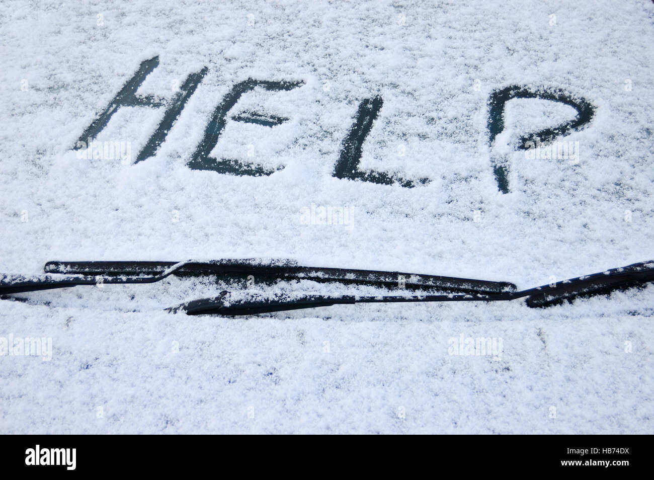 Schneebedeckte Auto Windschutzscheibe mit der Word-Hilfe im Schnee geschrieben Stockfoto