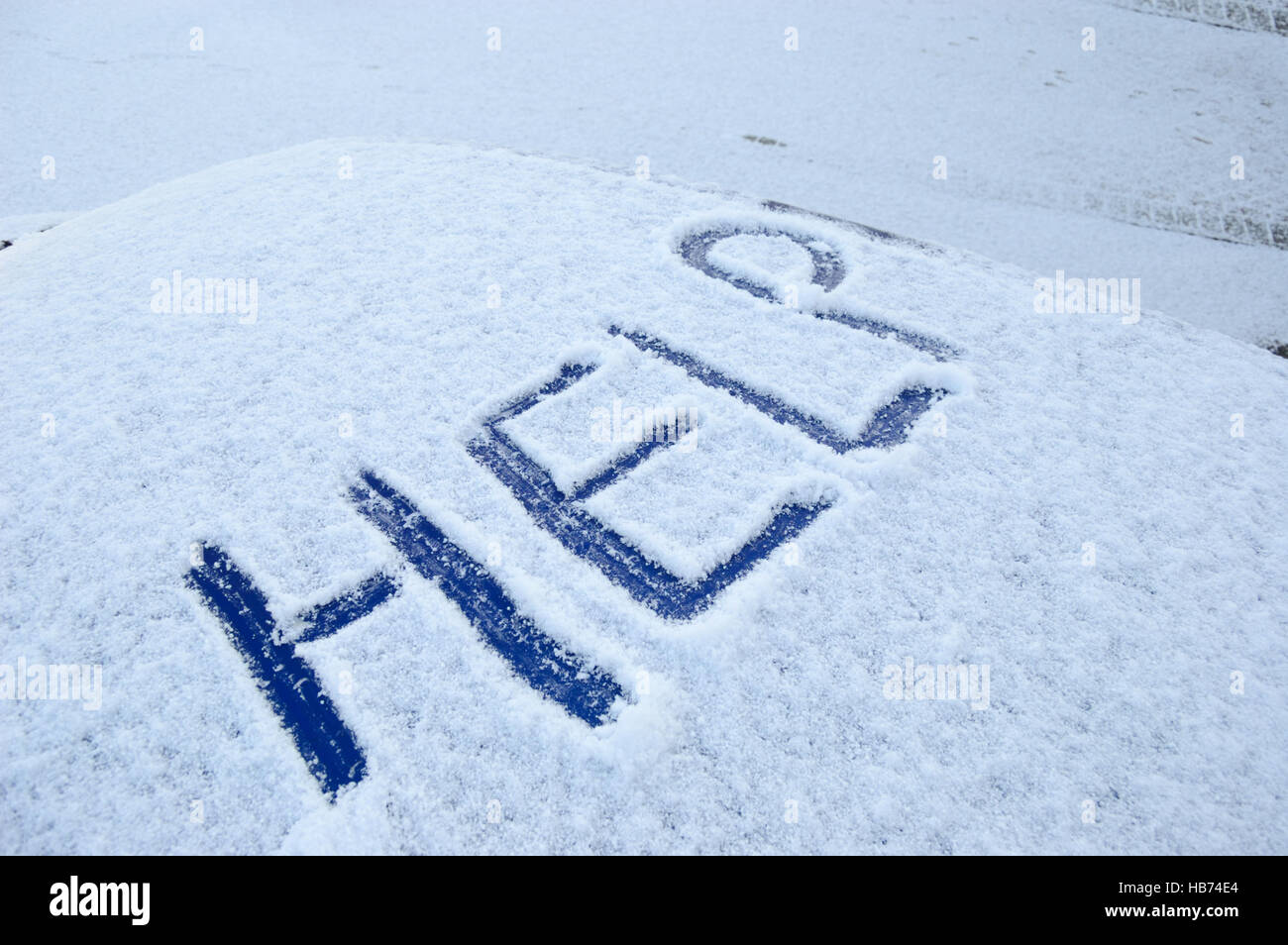 Schneebedeckte Autodach mit der Word-Hilfe im Schnee geschrieben Stockfoto