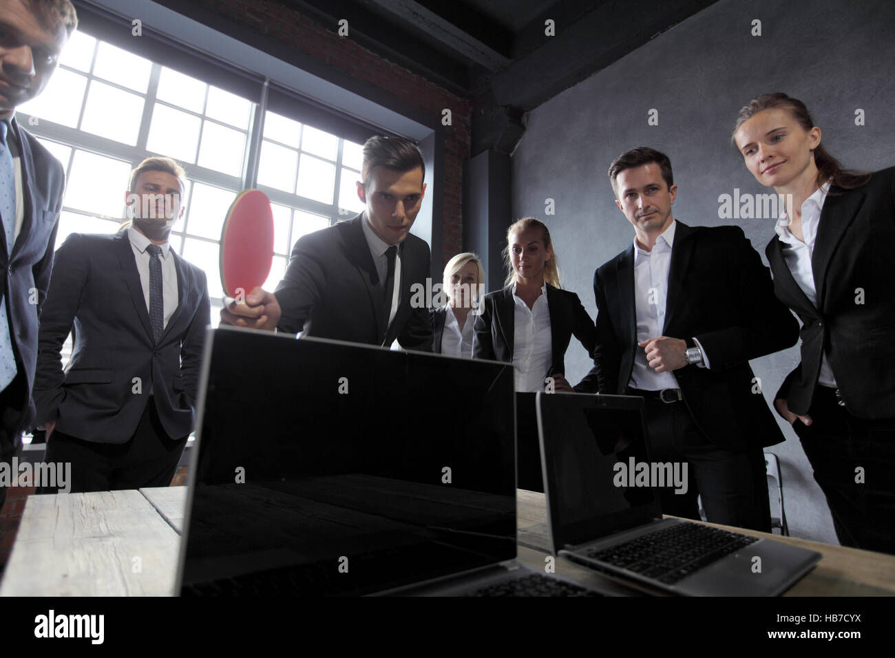 Business-Leute spielen Ping-Pong auf Bürotisch mit laptops Stockfoto