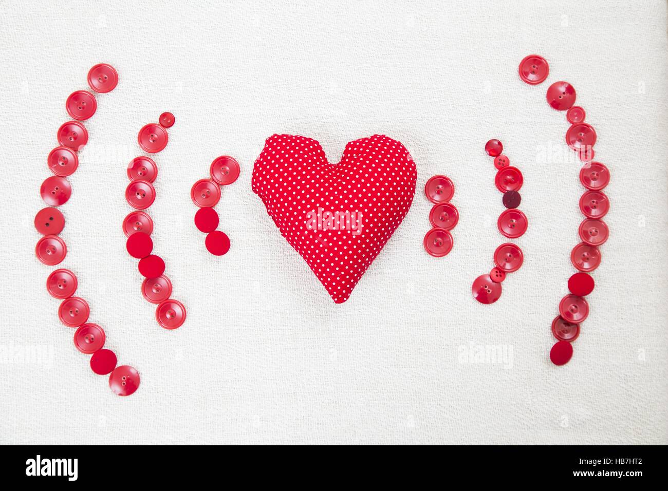Herz-Kissen umgeben von roten Wifi geformte Tasten. Stockfoto