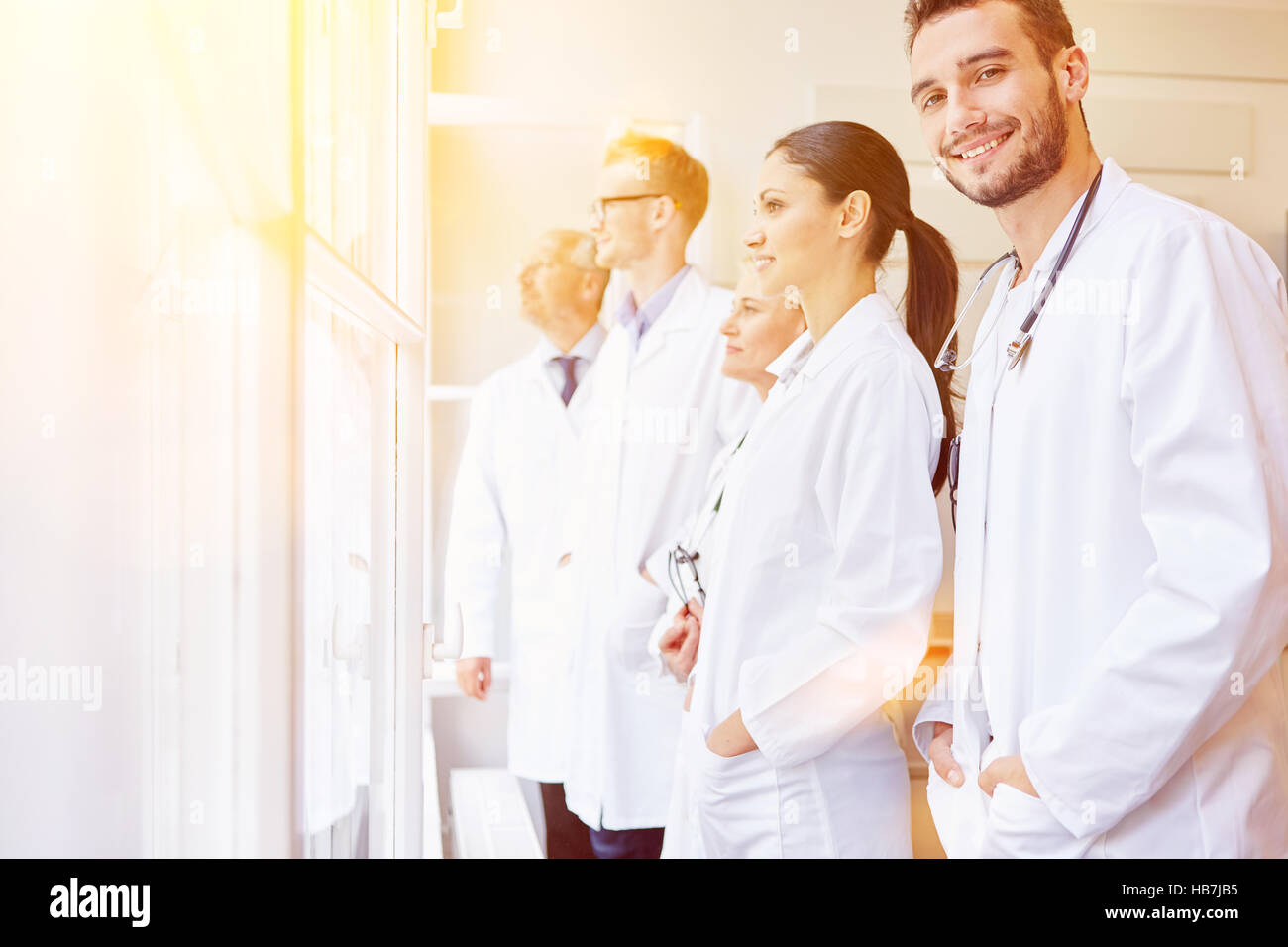 Team von Ärzten, die man Fenster im Krankenhaus als Gruppe Stockfoto