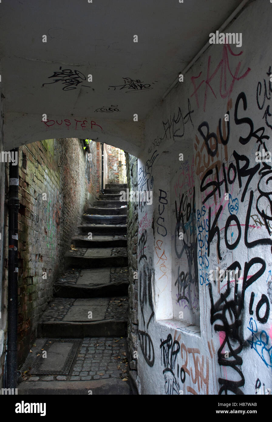 Wand Graffiti in schmalen Furnel oder Gasse mit Stufen und gepflasterten Gehweg nach oben Stockfoto