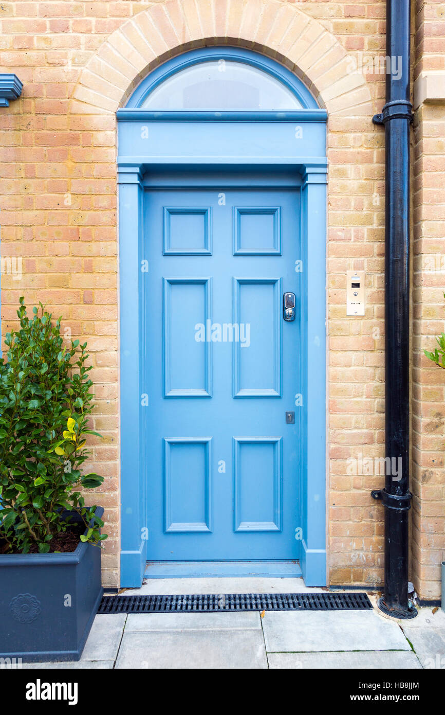 Leichte blaue Tür in einem gelben Haus Stockfoto
