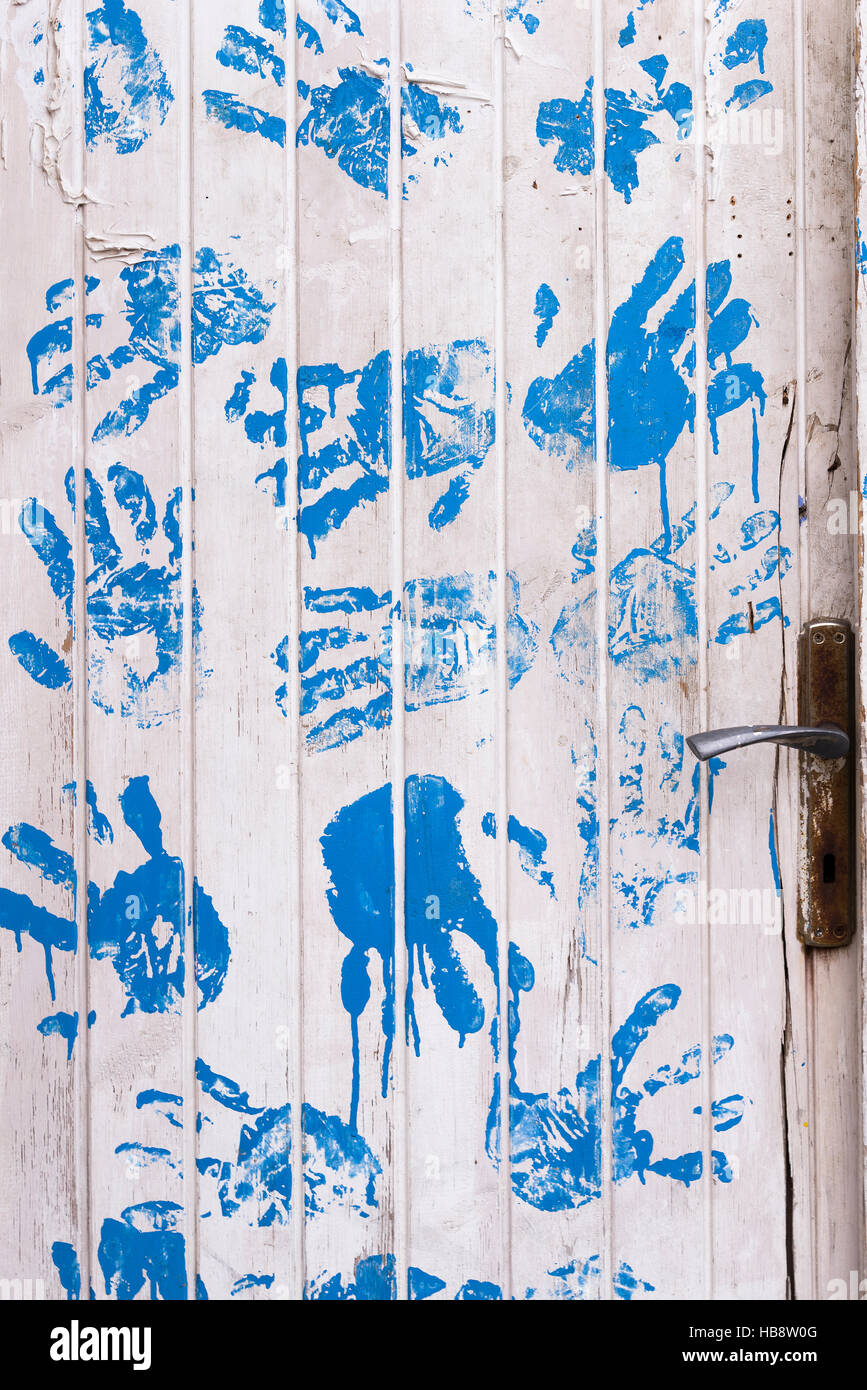 Weiße Holztür mit blauen Handabdrücke. Stockfoto