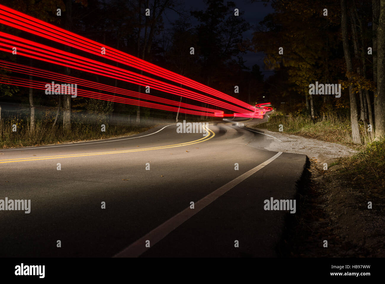 Straße in der Nacht mit Autos fahren auf und ab, wodurch Lichtspuren gekrümmt. Stockfoto