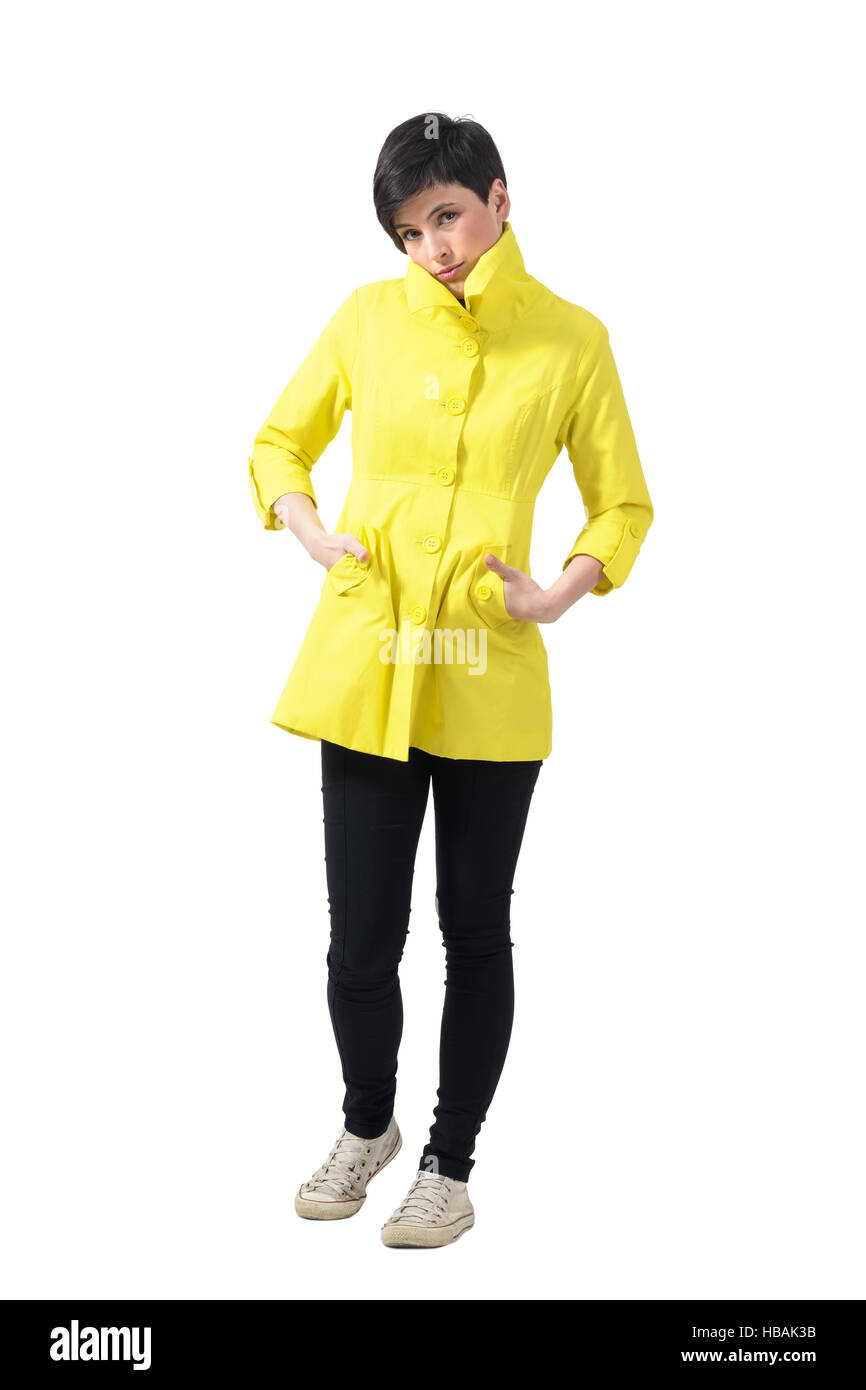 Traurige Einfrieren Frau im gelben Regenmantel mit Händen in den Taschen. Ganzkörper-Länge-Porträt über weiße Studio-Hintergrund isoliert. Stockfoto
