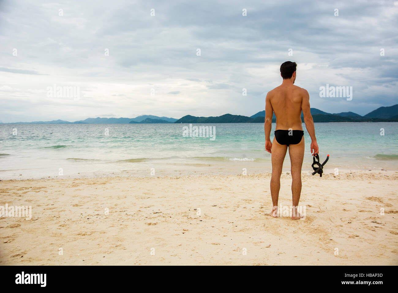 Mann am Strand stehen und halten Tauchermaske. Horizontal im Freien gedreht Stockfoto