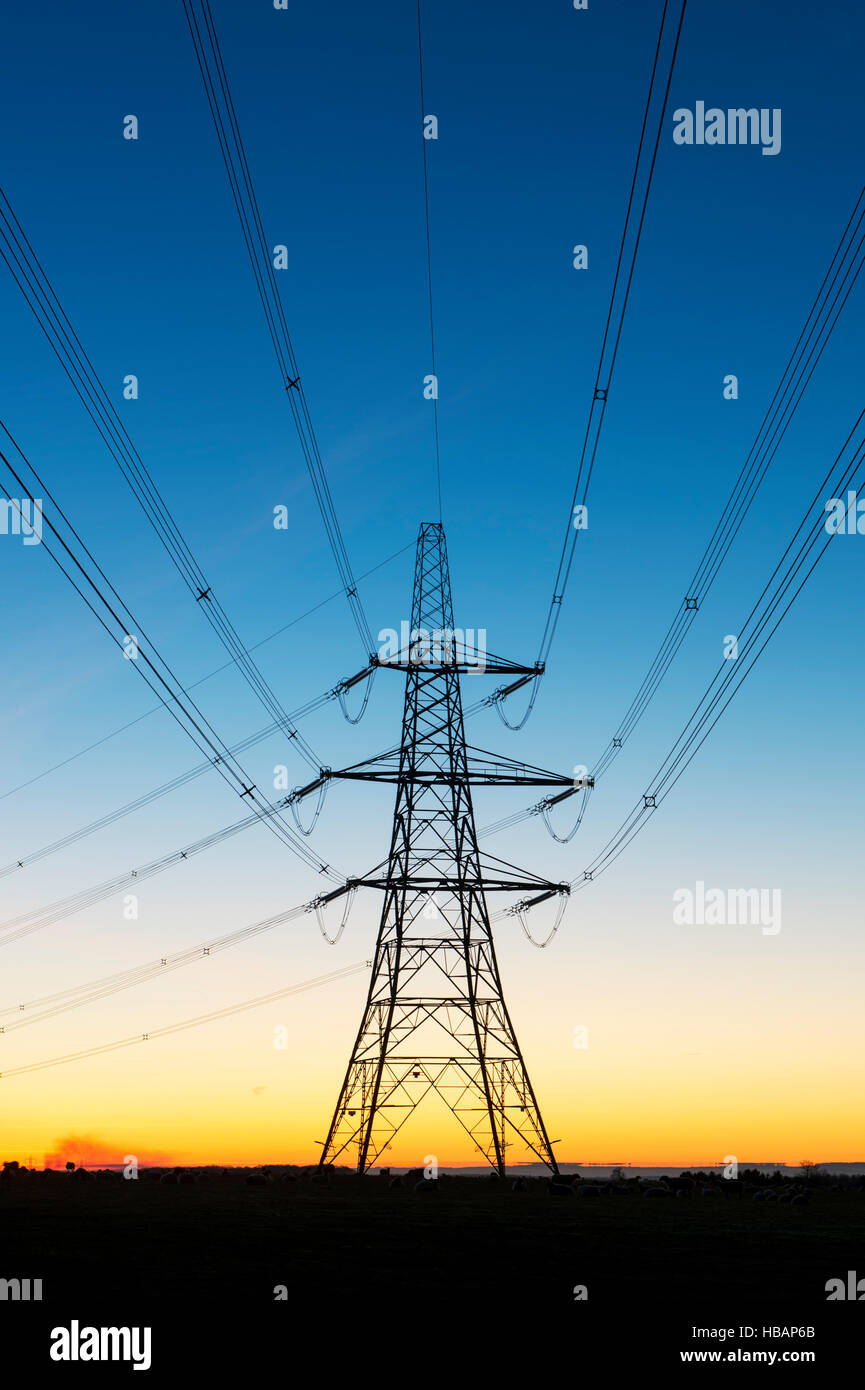 Die Silhouette des elektrischen Pylons vor dem Morgenhimmel. Cotswolds, England Stockfoto