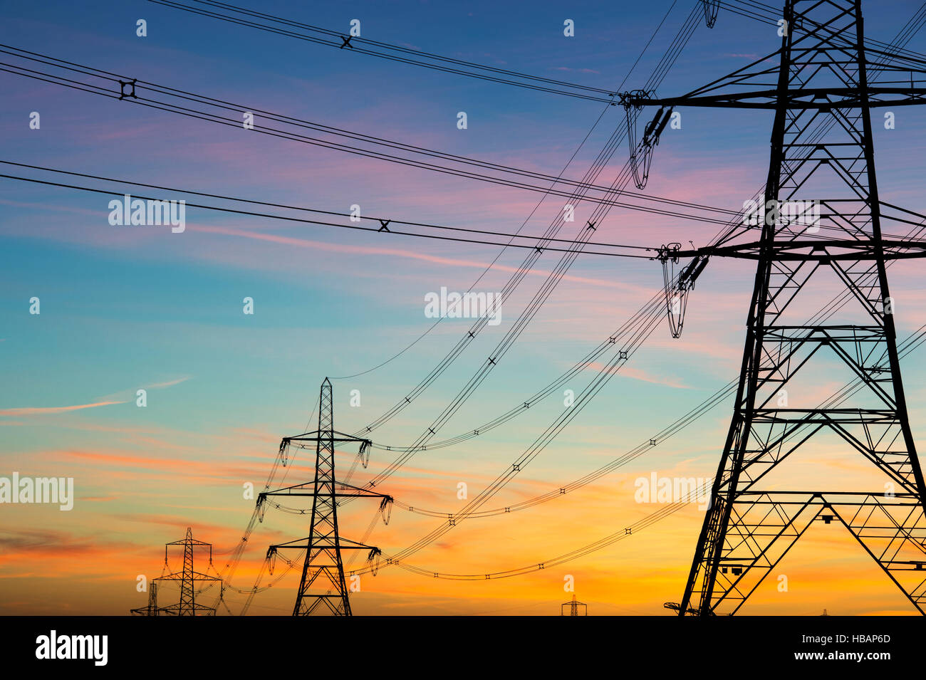 Elektrizität Masten Silhouette vor Sonnenaufgang Himmel. UK Stockfoto