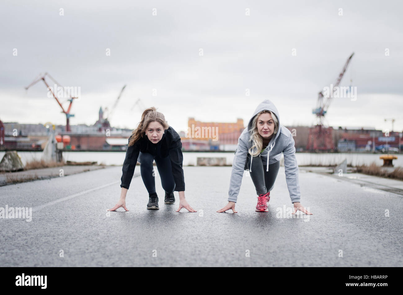 Zwei Freundinnen laufen auf ihre Spuren am Hafen unterwegs Stockfoto