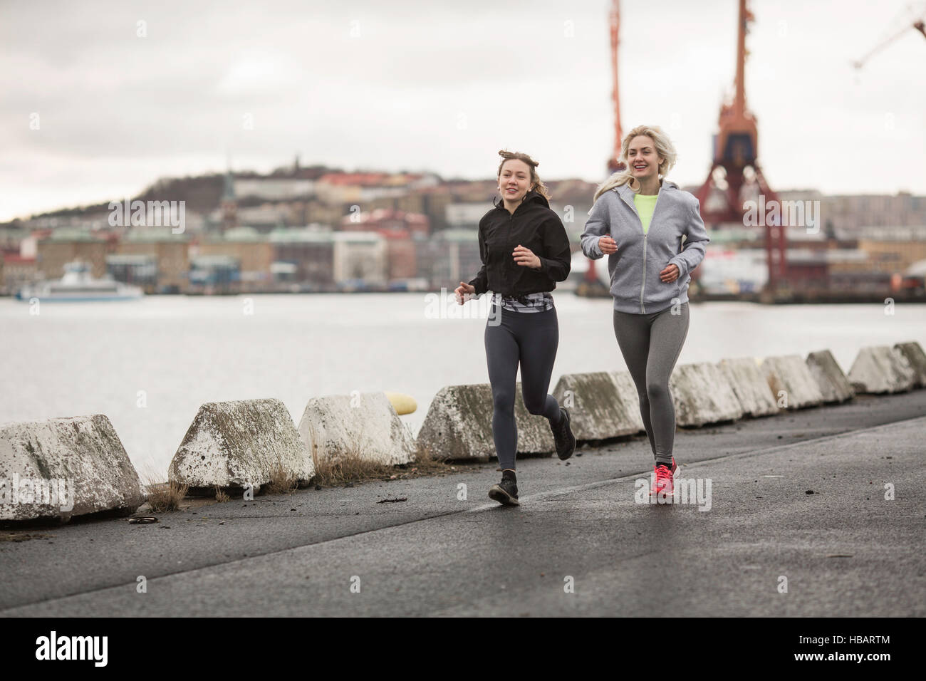 Zwei weibliche Läufer Freunde entlang am Hafen Stockfoto
