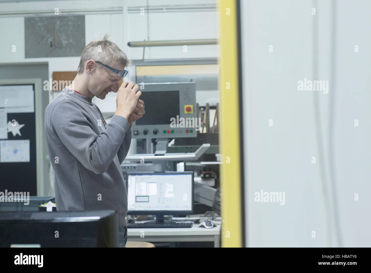 Mann sucht in Lupe Lupe in Werkstatt Stockfoto