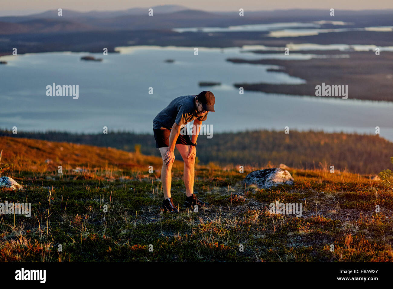 Menschen, die Ruhe nach dem Ausführen auf Klippe bei Sonnenuntergang, Keimiotunturi, Lappland, Finnland Stockfoto