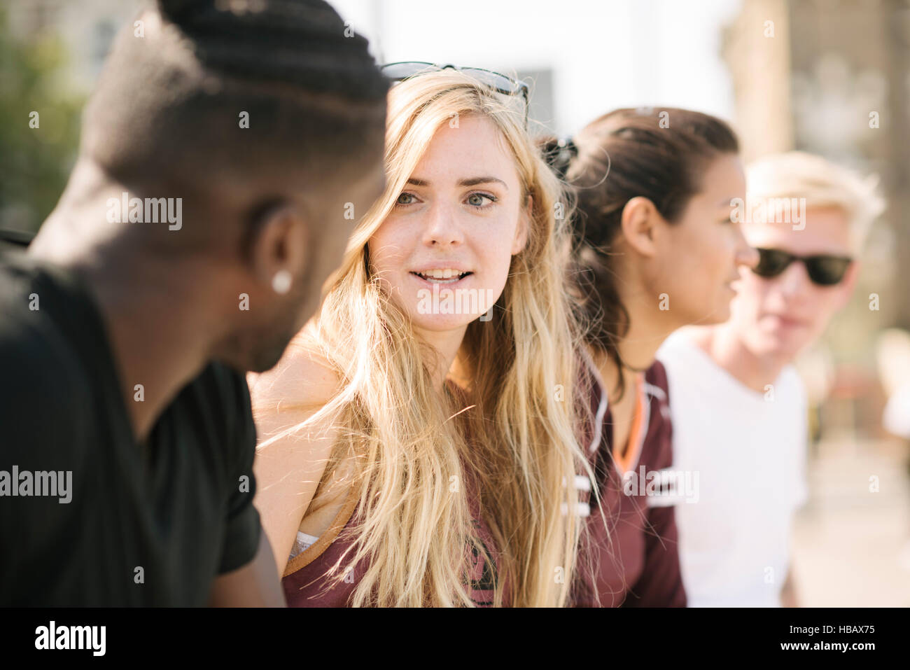 Reihe von vier männlichen und weiblichen Freunden chatten in Stadt skatepark Stockfoto