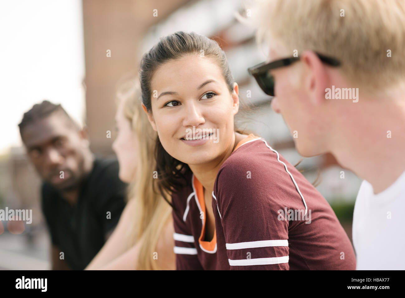 Reihe von vier männlichen und weiblichen Freunden chatten in Stadt skatepark Stockfoto